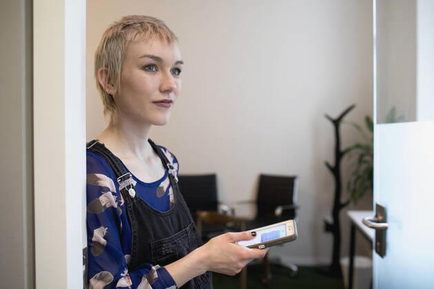 Young professional woman checkingher smart phone at the office. model release HEX17003_TP_9966 Copyright: xTOBIASxPRASSEx