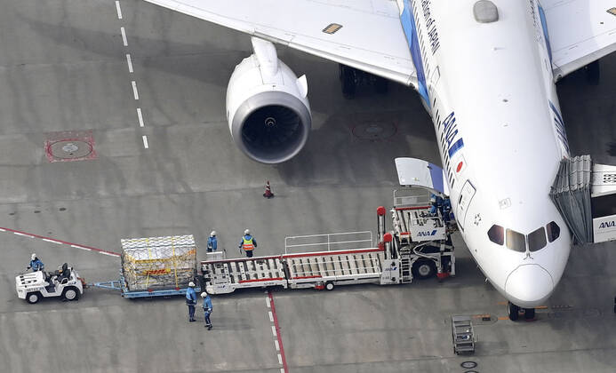 1st batch of Pfizer COVID-19 vaccine arrives in Japan Photo taken from a Kyodo News helicopter on Feb. 12, 2021, shows cargo being unloaded at Narita airport near Tokyo from an airplane that transported from Brussels the first batch to arrive in Japan of the coronavirus vaccine developed by U.S. pharmaceutical giant Pfizer Inc. 