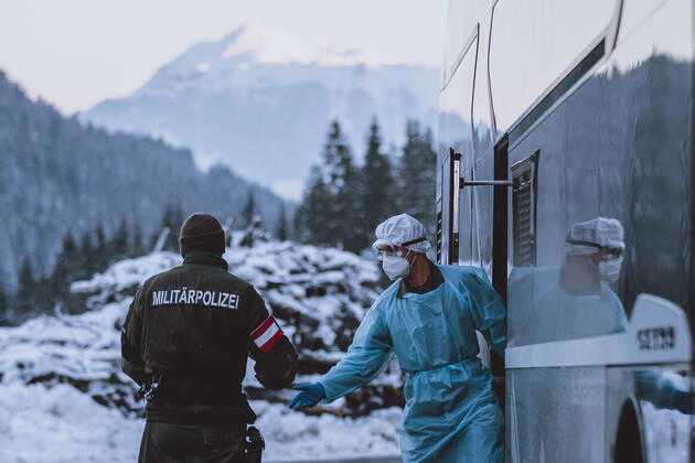 Jochberg 12.02.2021, Jochberg, AUT, Coronaviruskrise, Tirol, im Bild ein Mitarbeiter des Testteams überreicht einen Militärpolizisten den Testbefund eines Ausreisenden. Seit Mitternacht wird bei der Ausreise aus Tirol kontrolliert, um die Weiterverbreitung der südafrikanischen Virusvariante B1.151 zu verhindern a member of the testing team hands over the result of a person to a military police officer at the Pass Thurn. Since midnight, there have been checks when leaving Tyrol to prevent the further spread of the South African virus mutation B1.151 , Jochberg, Austria on 2021 02 12.
