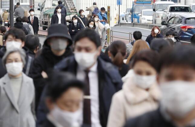 Japan s fight against coronavirus People wearing face masks to protect against the novel coronavirus walk in Tokyo s Shinjuku area on Feb. 12, 2021. 