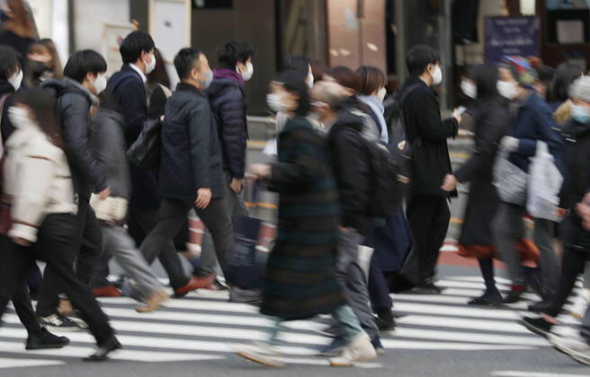 Japan s fight against coronavirus People wearing face masks to protect against the novel coronavirus walk in Tokyo s Shinjuku area on Feb. 12, 2021. 