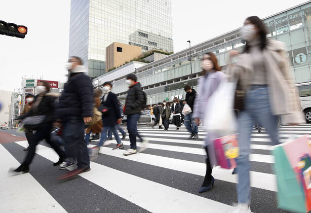 Japan s fight against coronavirus People wearing face masks to protect against the novel coronavirus walk in Tokyo s Shinjuku area on Feb. 12, 2021. 