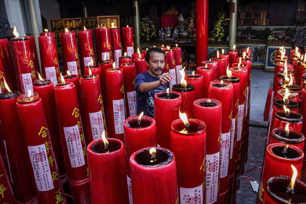 February 12, 2021, Bandung, West Java, Indonesia: A man lights candles at the Dharma Ramsi Temple during the Lunar New Year celebrations..The Lunar New Year, also known as Spring Festival, falls on 12 February 2021, marking the beginning of the Year of the Ox. Bandung Indonesia - ZUMAs197 20210212_zaa_s197_068 Copyright: xAlgixFebrixSugitax