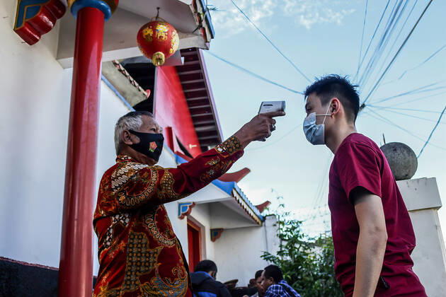 February 12, 2021, Bandung, West Java, Indonesia: A Temple staff checks the body temperature of a man at the Dharma Ramsi Temple during the Lunar New Year celebrations..The Lunar New Year, also known as Spring Festival, falls on 12 February 2021, marking the beginning of the Year of the Ox. Bandung Indonesia - ZUMAs197 20210212_zaa_s197_070 Copyright: xAlgixFebrixSugitax