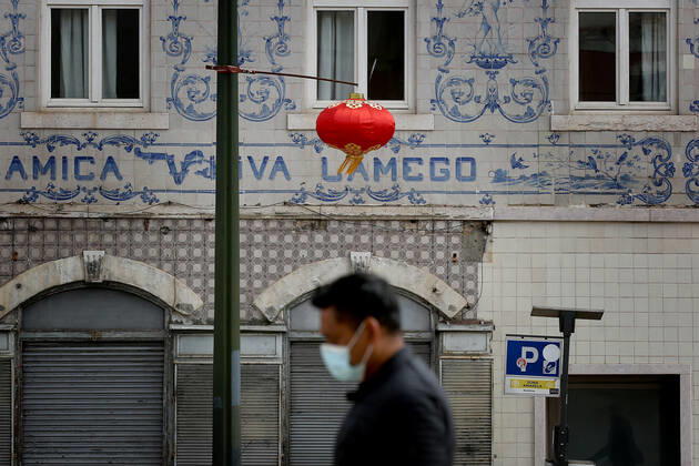 February 12, 2021, Lisbon, Portugal: A men wearing a face mask walks under a red lantern that were put up for the Chinese New Year marking the Year of the Ox at Almirante Reis avenue in Lisbon, Portugal on February 12, 2021. This year, with restrictions imposed by the state of emergency in Portugal due to the COVID-19 pandemic, online broadcasting replaces Chinese New Year celebrations, such as the traditional parade with dragons, snakes and acrobats, which attracts hundreds of people every year to the Almirante Reis avenue, however the traditional red lanterns adorn the avenue, to mark the event. Lisbon Portugal - ZUMAf123 20210212_zap_f123_001 Copyright: xPedroxFiuzax