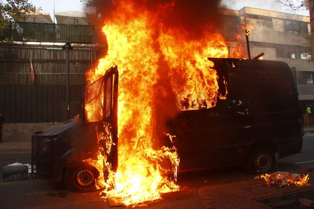 Photograph of a Carabineros vehicle on fire during a demonstration in Plaza Italia in Santiago, Chile, 12 February 2021. The Chilean capital this Friday experienced a new day of protests against the government of President Sebastian Pinera and in rejection of police abuse after the death of juggler Francisco Martinez, shot dead by the Carabineros (militarized police) in a routine identity check. The death of the artist rekindled criticism of the Carabineros and demands to refound the police force. Santiago de Chile lives a new day of protests against the Government and the Carabineros !ACHTUNG: NUR REDAKTIONELLE NUTZUNG!  Copyright: xSebastianxSilvax AME5446 20210213-637487795824875432
