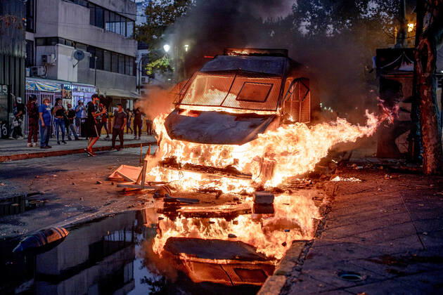 February 12, 2021, Santiago, Chile: Protester watch as a police vehicle burns down during a protest against police brutality in Santiago..Several protesters took to the streets in a protest that saw a police vehicle being burnt down following the death of a street artist who was shot by police in the city of Panguipulli after he refused to co-operate with a police search. Santiago Chile - ZUMAs197 20210212_zaa_s197_241 Copyright: xPabloxRojasxMadariagax