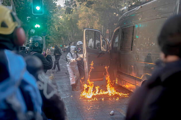 February 12, 2021, Santiago, Region Metropolitana, Chile: Protesters set a police vehicle on fire as others look on during protests against police brutality in Santiago..Several protesters took to the streets in a protest against President Sebastian Pinera s government, attacking and burning a police vehicle hence injuring an officer following the death of a street artist who was shot by police in the city of Panguipulli after he refused to co-operate with a police search. Santiago Chile - ZUMAs197 20210212_zaa_s197_271 Copyright: xFelipexFigueroax