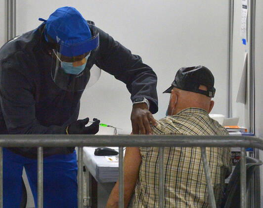 A local resident receives a COVID-19 shot at the Cal Poly Pomona mass vaccination site in Pomona, California on Saturday, February 13, 2021. A 78-year-old woman passed away unexpectedly Friday shortly after receiving Pfizer s version of the COVID-19 vaccine at the Kaiser-run site. The patient s family said she had a history of heart illness. Her cause of death was yet to be determined, but the Los Angeles County Department of Public Health said by email that there were no signs of allergic or anaphylactic reactions. Her death does not appear to be related to the vaccine, it said.  LAP2021021305 JIMxRUYMEN