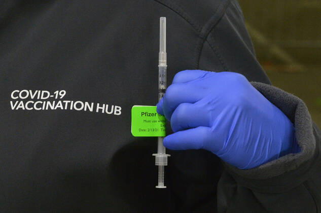 A pharmacist holds a syringe with a prepared COVID-19 vaccine at the Cal Poly Pomona mass vaccination site in Pomona, California on Saturday, February 13, 2021. A 78-year-old woman passed away unexpectedly Friday shortly after receiving Pfizer s version of the COVID-19 vaccine at the Kaiser-run site. The patient s family said she had a history of heart illness. Her cause of death was yet to be determined, but the Los Angeles County Department of Public Health said by email that there were no signs of allergic or anaphylactic reactions. Her death does not appear to be related to the vaccine, it said.  LAP2021021311 JIMxRUYMEN