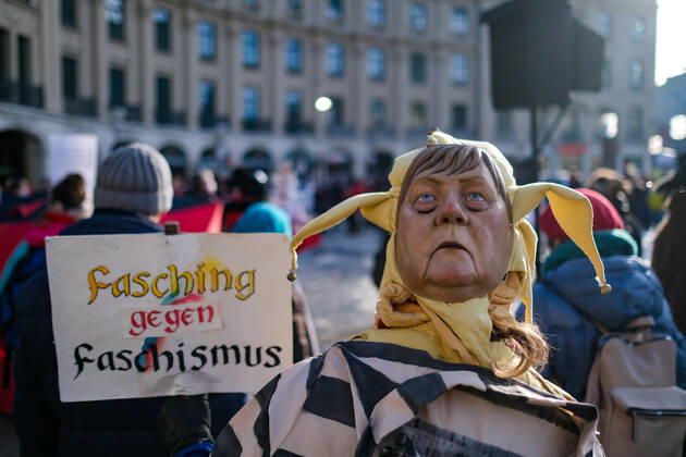 News Bilder des Tages Demonstration gegen Corona Auflagen 14.02.2021 MÜNCHEN Ein Teilnehmer einer Kundgebung gegen die Corona Auflagen auf dem Karlsplatz (Stachus) in der Münchner Innenstadt am Faschingssonntag. Er trägt eine Maske mit dem Gesicht der Bundeskanzlerin Angela Merkel. München Bayern Deutschland