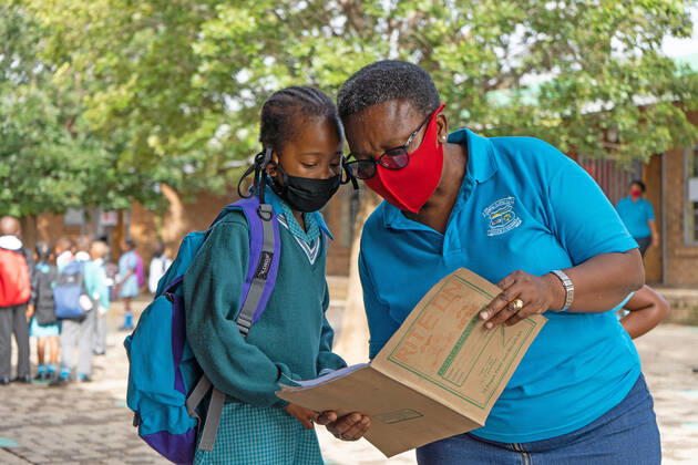 (210216) -- JOHANNESBURG, Feb. 16, 2021 -- A teacher checks a student s information at a primary school in Johannesburg, South Africa, Feb. 15, 2021. Over 20,000 public schools in South Africa were reopened in accordance with strict adherence to the COVID-19 protocol on Monday. (Photo by Xinhua) SOUTH AFRICA-JOHANNESBURG-COVID-19-PUBLIC SCHOOL-REOPEN MatthewxMartinxBrink 