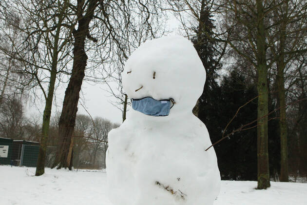 Ein Schneemann mit einer Maske steht im Hamburger Stadtpark. Winterhude Hamburg