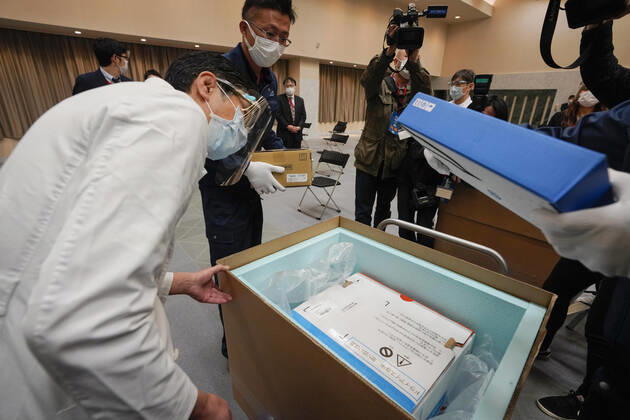 February 16, 2021, TOKYO, TOKYO, Japan: A Tokyo hospital staff checks temperature of Pfizer Inc s COVID-19 vaccine with delivery staff at the hospital in Tokyo, Japan, 16 February 2021. Japan will start the vaccinations with about 40,000 medical workers on 17 February 2021 after Japanese government approved the vaccine on 14 February 2021. TOKYO Japan - ZUMAz114 20210216_zih_z114_002 Copyright: xPOOLx