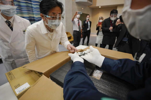 February 16, 2021, TOKYO, TOKYO, Japan: A Tokyo hospital staff checks condition of Pfizer Inc s COVID-19 vaccine with delivery staff at the hospital in Tokyo, Japan, 16 February 2021. Japan will start the vaccinations with about 40,000 medical workers on 17 February 2021 after Japanese government approved the vaccine on 14 February 2021. TOKYO Japan - ZUMAz114 20210216_zih_z114_003 Copyright: xPOOLx