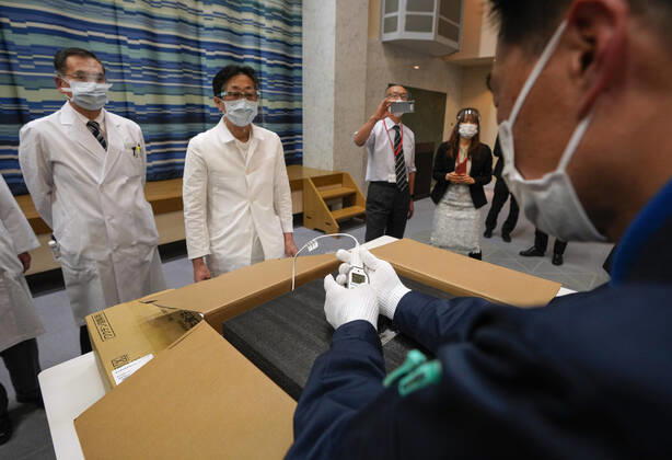 February 16, 2021, TOKYO, TOKYO, Japan: A Tokyo hospital staff checks condition of Pfizer Inc s COVID-19 vaccine with delivery staff at the hospital in Tokyo, Japan, 16 February 2021. Japan will start the vaccinations with about 40,000 medical workers on 17 February 2021 after Japanese government approved the vaccine on 14 February 2021. TOKYO Japan - ZUMAz114 20210216_zih_z114_006 Copyright: xPOOLx