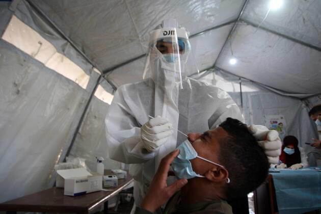 A Palestinian paramedic wearing a full protective suit, administers a COVID-19 test on Tuesday, February 16, 2021 in Khan Yunis, southern Gaza. The Palestinian Authority claims that Israel is stopping delivery of COVID-19 vaccines into Gaza, from the West Bank.  GAZ2021021606 IsmaelxMohamad
