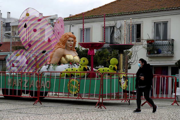 February 16, 2021, Lisbon, Portugal: A woman wearing a facial protective mask walks by a carnival float on display in Loures, on the outskirts of Lisbon, Portugal, on February 16, 2021. Portugal s carnival parades and festivities had to be canceled as part of ongoing lockdown measures against COVID-19 pandemic, but some municipalities have adapted and asked revelers to party in their windows or online. Lisbon Portugal - ZUMAf123 20210216_zap_f123_005 Copyright: xPedroxFiuzax