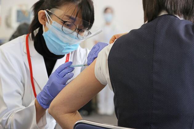 Japan begins COVID-19 vaccine to health workers A health worker inoculates a colleague with COVID-19 vaccine at the Tokyo Medical Center in Tokyo s Meguro Ward on Feb. 17, 2021. Japan began COVID-19 vaccinations the same day, with the first shots given at the state-run hospital. (Pool photo) 