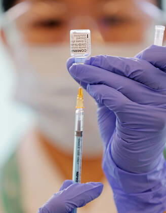 Japan begins COVID-19 vaccine to health workers A health worker injects COVID-19 vaccine from a bottle into a syringe at the Tokyo Medical Center in Tokyo s Meguro Ward on Feb. 17, 2021. Japan began COVID-19 vaccinations the same day, with the first shots given at the state-run hospital. (Pool photo) 