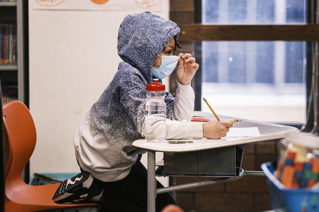 February 17, 2021, Des Moines, Iowa, U.S: A fourth grade student adjusts his mask at his desk at Walnut Street School in downtown Des Moines. Des Moines Public Schools (DMPS) opened to in person education this week after teaching most of the 2020-2021 school year either remotely or with a hybrid remote learning model. Elementary school classrooms, which used to sit 2-4 students at a table, have gone to individual desks, placed 6 feet apart, in classrooms. Students are required to wear masks for most class activities. The district has ended its hybrid model. The Governor of Iowa has aggressively pushed schools to return to in person education, going so far as to threaten to withhold funds from districts that don t return to in person classes - ZUMAk94_ 20210217_zaf_k94_009 Copyright: xJackxKurtzx