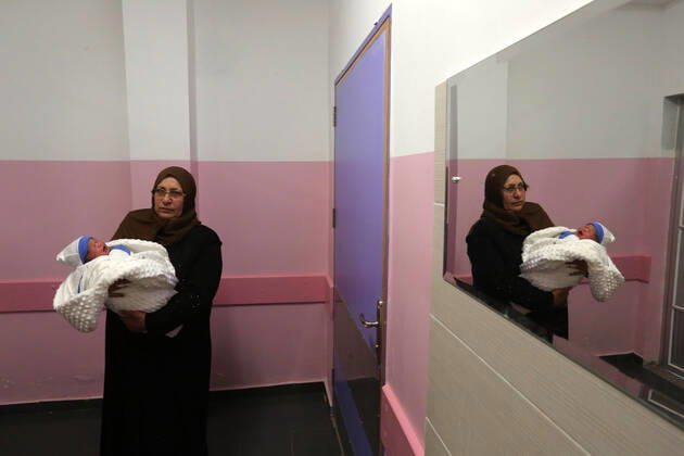 February 18, 2021, khan Younis, Gaza Strip, Palestinian Territory: Relatives of the Palestinian prisoner Muhammad al-Qudra carry the newborn, at Nasser Medical Complex in khan Younis in the southern of Gaza strip on February 18, 2021. Eman al-Qudra gave birth to her newborn in a successful smuggling of sperm to lead to a pregnancy. Since 2004, Palestinian security prisoners, who are denied conjugal visitations by their wives, have tried to smuggle their sperm out of Israeli prisons, so that their wives can be inseminated in fertility clinics in the West Bank and Ghazza, and bear them children khan Younis Palestinian Territory - ZUMAap3_ 20210218_zaf_ap3_178 Copyright: xAshrafxAmrax