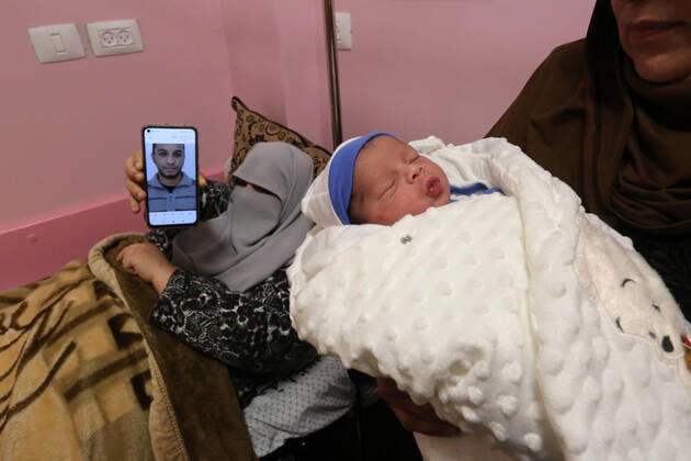 February 18, 2021, khan Younis, Gaza Strip, Palestinian Territory: The wife of the Palestinian prisoner Mohammad al-Qudra displays her husband s picture, who is imprisoned in Israeli prisons, on the mobile phone, at Nasser Medical Complex in khan Younis in the southern of Gaza strip on February 18, 2021. Since 2004, Palestinian security prisoners, who are denied conjugal visitations by their wives, have tried to smuggle their sperm out of Israeli prisons, so that their wives can be inseminated in fertility clinics in the West Bank and Ghazza, and bear them children khan Younis Palestinian Territory - ZUMAap3_ 20210218_zaf_ap3_191 Copyright: xAshrafxAmrax
