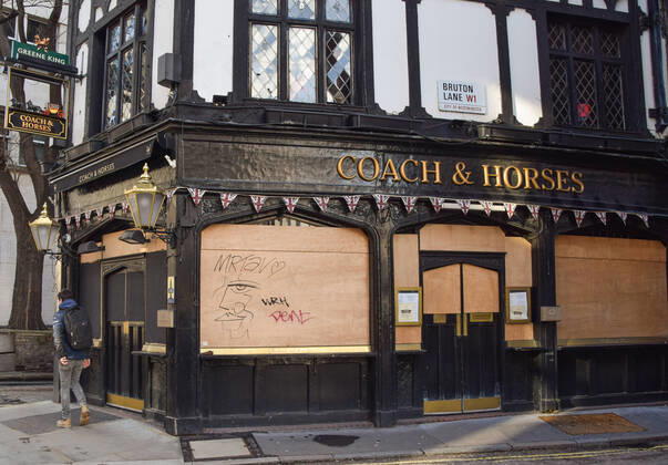 February 18, 2021, London, United Kingdom: A man walks past the closed Coach & Horses pub in Central London..Coronavirus cases are falling across the UK, as the government prepares to present its plan for easing the lockdown restrictions. London United Kingdom - ZUMAs197 20210218_zaa_s197_202 Copyright: xVukxValcicx
