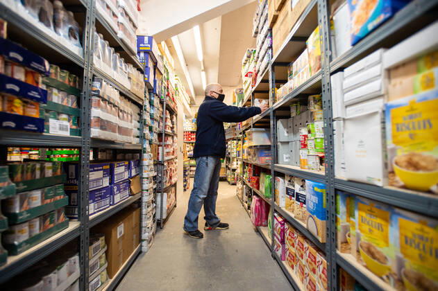 A volunteer helps pack food at the FC United Foodhub for distribution amongst residents and vulnerable groups affected by the Coronavirus pandemic, on 19 February 2021. The food bank is situated at Broadhurst Park, home of non-league football team FC United of Manchester. Broadhurst Park is situated in the Moston area of the city, where a new strain of the Coronavirus, E484K, has been detected in the community over the past few days. The club has been shortlisted in the Football SupportersÕ Association Lockdown Heroes Awards for 2020. Moston Greater Manchester England Broadhurst Park  Copyright: xMattxWilkinsonx