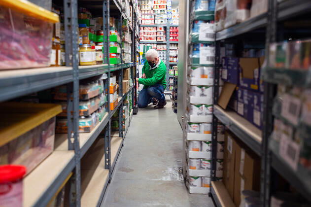 A volunteer helps pack food at the FC United Foodhub for distribution amongst residents and vulnerable groups affected by the Coronavirus pandemic, on 19 February 2021. The food bank is situated at Broadhurst Park, home of non-league football team FC United of Manchester. Broadhurst Park is situated in the Moston area of the city, where a new strain of the Coronavirus, E484K, has been detected in the community over the past few days. The club has been shortlisted in the Football SupportersÕ Association Lockdown Heroes Awards for 2020. Moston Greater Manchester England Broadhurst Park  Copyright: xMattxWilkinsonx