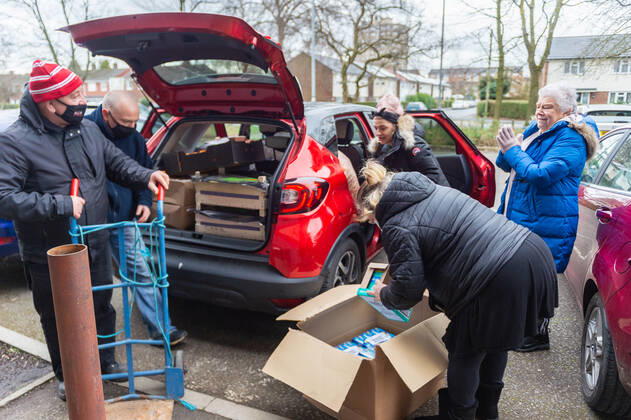 Volunteers help pack food in to a community group s vehicle at the FC United Foodhub for distribution amongst residents and vulnerable groups affected by the Coronavirus pandemic, on 19 February 2021. The food bank is situated at Broadhurst Park, home of non-league football team FC United of Manchester. Broadhurst Park is situated in the Moston area of the city, where a new strain of the Coronavirus, E484K, has been detected in the community over the past few days. The club has been shortlisted in the Football SupportersÕ Association Lockdown Heroes Awards for 2020. Moston Greater Manchester England Broadhurst Park  Copyright: xMattxWilkinsonx