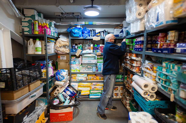 A volunteer helps pack food at the FC United Foodhub for distribution amongst residents and vulnerable groups affected by the Coronavirus pandemic, on 19 February 2021. The food bank is situated at Broadhurst Park, home of non-league football team FC United of Manchester. Broadhurst Park is situated in the Moston area of the city, where a new strain of the Coronavirus, E484K, has been detected in the community over the past few days. The club has been shortlisted in the Football SupportersÕ Association Lockdown Heroes Awards for 2020. Moston Greater Manchester England Broadhurst Park  Copyright: xMattxWilkinsonx