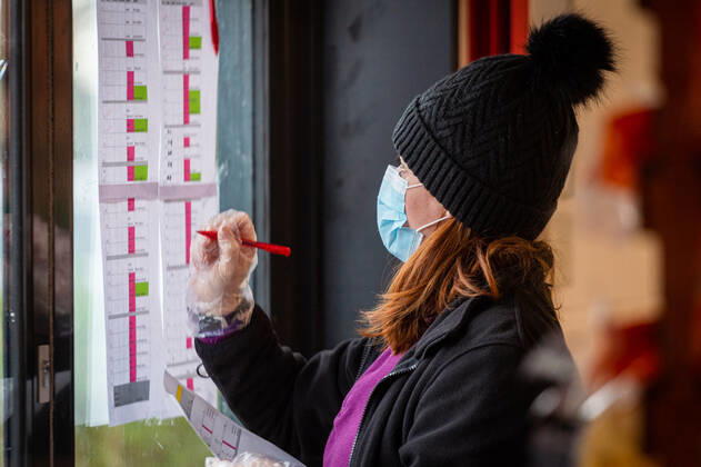 A volunteer checks off a food package at the FC United Foodhub, for distribution amongst residents and vulnerable groups affected by the Coronavirus pandemic, on 19 February 2021. The food bank is situated at Broadhurst Park, home of non-league football team FC United of Manchester. Broadhurst Park is situated in the Moston area of the city, where a new strain of the Coronavirus, E484K, has been detected in the community over the past few days. The club has been shortlisted in the Football SupportersÕ Association Lockdown Heroes Awards for 2020. Moston Greater Manchester England Broadhurst Park  Copyright: xMattxWilkinsonx