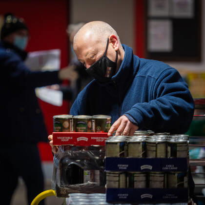 A volunteer helps pack food at the FC United Foodhub for distribution amongst residents and vulnerable groups affected by the Coronavirus pandemic, on 19 February 2021. The food bank is situated at Broadhurst Park, home of non-league football team FC United of Manchester. Broadhurst Park is situated in the Moston area of the city, where a new strain of the Coronavirus, E484K, has been detected in the community over the past few days. The club has been shortlisted in the Football SupportersÕ Association Lockdown Heroes Awards for 2020. Moston Greater Manchester England Broadhurst Park  Copyright: xMattxWilkinsonx