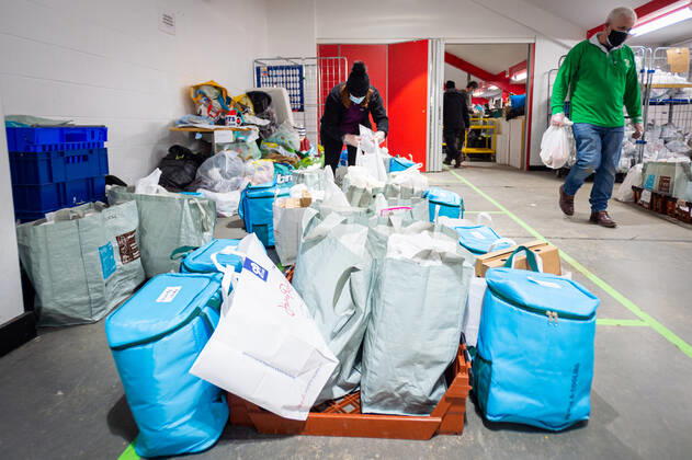 A volunteer helps pack food at the FC United Foodhub for distribution amongst residents and vulnerable groups affected by the Coronavirus pandemic, on 19 February 2021. The food bank is situated at Broadhurst Park, home of non-league football team FC United of Manchester. Broadhurst Park is situated in the Moston area of the city, where a new strain of the Coronavirus, E484K, has been detected in the community over the past few days. The club has been shortlisted in the Football SupportersÕ Association Lockdown Heroes Awards for 2020. Moston Greater Manchester England Broadhurst Park  Copyright: xMattxWilkinsonx