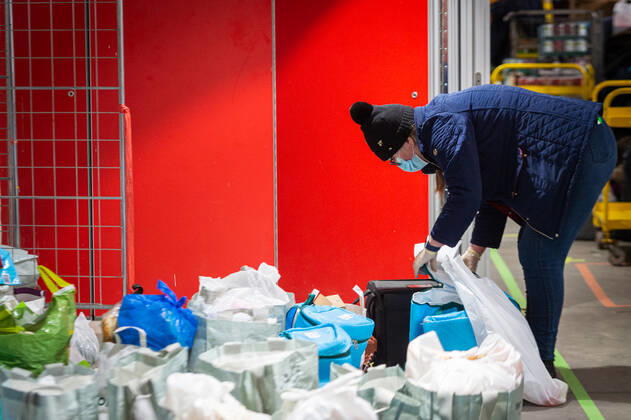 A volunteer helps pack food at the FC United Foodhub for distribution amongst residents and vulnerable groups affected by the Coronavirus pandemic, on 19 February 2021. The food bank is situated at Broadhurst Park, home of non-league football team FC United of Manchester. Broadhurst Park is situated in the Moston area of the city, where a new strain of the Coronavirus, E484K, has been detected in the community over the past few days. The club has been shortlisted in the Football SupportersÕ Association Lockdown Heroes Awards for 2020. Moston Greater Manchester England Broadhurst Park  Copyright: xMattxWilkinsonx