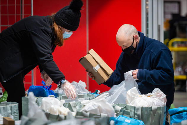 Volunteers help pack food at the FC United Foodhub for distribution amongst residents and vulnerable groups affected by the Coronavirus pandemic, on 19 February 2021. The food bank is situated at Broadhurst Park, home of non-league football team FC United of Manchester. Broadhurst Park is situated in the Moston area of the city, where a new strain of the Coronavirus, E484K, has been detected in the community over the past few days. The club has been shortlisted in the Football Supporters™ Association Lockdown Heroes Awards for 2020. Moston Greater Manchester England Broadhurst Park  Copyright: xMattxWilkinsonx