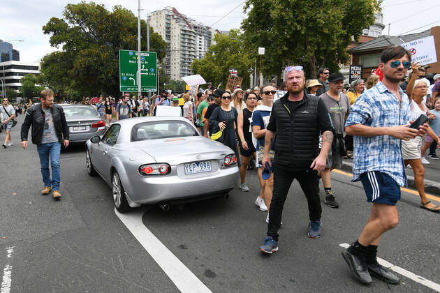 ANTI VACCINATION RALLY MELBOURNE, Protesters walk through traffic during an anti-vaccination rally in Melbourne, Saturday, February 20, 2021. The national rollout of the Pfizer vaccine will begin on Monday in what will be the largest exercise of its kind in Australia s history. ( NO ARCHIVING, EDITORIAL USE ONLY, NO USE IN BOOKS WITHOUT CONSENT MELBOURNE VIC AUSTRALIA  Copyright: xERIKxANDERSONx 20210220001521827084