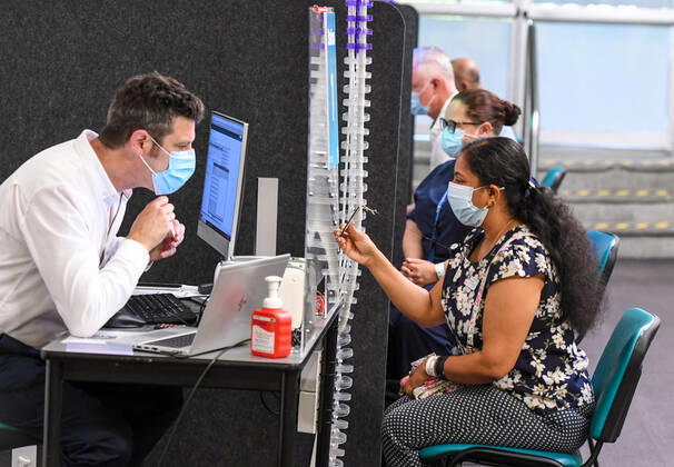 NSW COVID19 VACCINE ROLLOUT, Gayathry Vellangalloor Srinivasan, the first person in NSW to received the Pfizer coronavirus vaccine, registers with medial workers at the Royal Prince Alfred Hospital Vaccination Hub in Sydney, Monday, February 22, 2021. Australia will begin its roll out of the Pfizer coronavirus vaccine on Monday, the country s most complicated logistical exercise to date. ( NO ARCHIVING, EDITORIAL USE ONLY, NO USE IN BOOKS WITHOUT CONSENT SYDNEY NSW AUSTRALIA Copyright: xPETERxRAEx 20210222001522241420