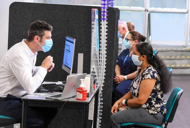 NSW COVID19 VACCINE ROLLOUT, Gayathry Vellangalloor Srinivasan, the first person in NSW to received the Pfizer coronavirus vaccine, registers with medial workers at the Royal Prince Alfred Hospital Vaccination Hub in Sydney, Monday, February 22, 2021. Australia will begin its roll out of the Pfizer coronavirus vaccine on Monday, the country s most complicated logistical exercise to date. ( NO ARCHIVING, EDITORIAL USE ONLY, NO USE IN BOOKS WITHOUT CONSENT SYDNEY NSW AUSTRALIA Copyright: xPETERxRAEx 20210222001522241450