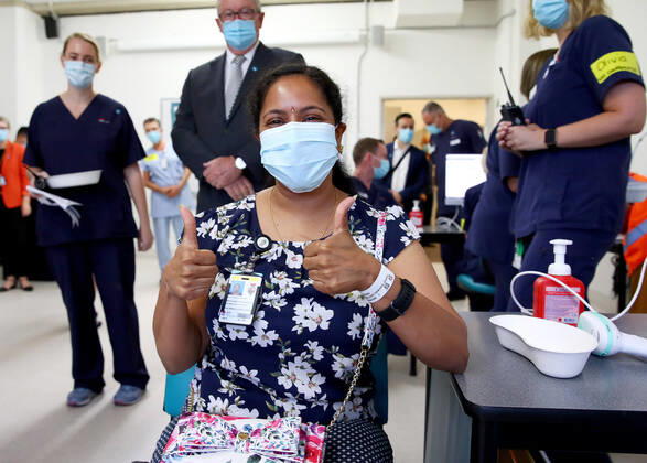 News Bilder des Tages NSW COVID19 VACCINE ROLLOUT, Gayathry Vellangalloor Srinivasan, an Environmental Services Supervisor, give two thumbs up after being the first person in NSW to receive the Pfizer vaccination at the Royal Prince Alfred Hospital Vaccination Hub in Sydney, Monday, February 22, 2021. Australia will begin its roll out of the Pfizer coronavirus vaccine on Monday, the country s most complicated logistical exercise to date. ( NO ARCHIVING, EDITORIAL USE ONLY, NO USE IN BOOKS WITHOUT CONSENT SYDNEY NSW AUSTRALIA  Copyright: xTobyxZernax 20210222001522248520