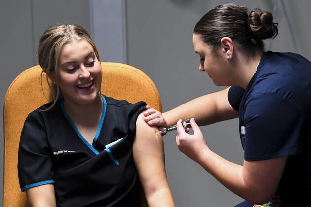 ACT COVID19 VACCINE ROLLOUT, Registered nurse Maddison Williams (left) receives the first jab of the Biotech Pfizer COVID-19 vaccine at the COVID-19 surge centre in Canberra, Monday, February 22, 2021. Australia will begin its roll out of the Pfizer coronavirus vaccine on Monday, the country s most complicated logistical exercise to date. ( NO ARCHIVING, EDITORIAL USE ONLY, NO USE IN BOOKS WITHOUT CONSENT CANBERRA ACT AUSTRALIA  Copyright: xLUKASxCOCHx 20210222001522299030