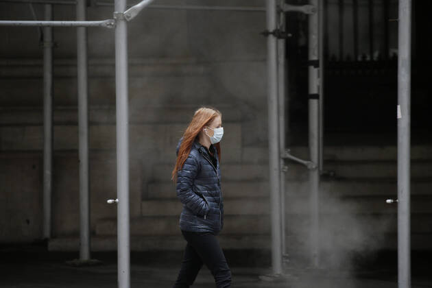 A pedestrian walks wearing a face mask to protect from and to prevent the spread of the coronavirus on Wall Street in New York City on Monday February 22, 2021. COVID-19 deaths have now surpassed the 500,000 mark in the United States.  NYP20210222106 JohnxAngelillo