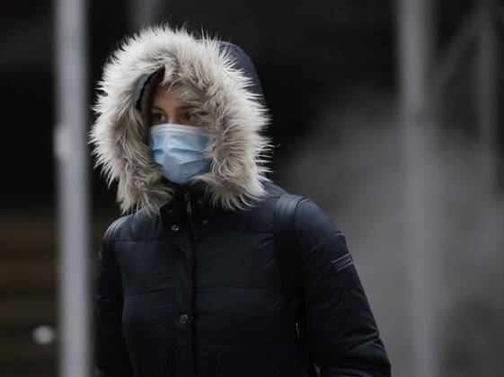 A pedestrian walks wearing a face mask to protect from and to prevent the spread of the coronavirus on Wall Street in New York City on Monday February 22, 2021. COVID-19 deaths have now surpassed the 500,000 mark in the United States.  NYP20210222109 JohnxAngelillo