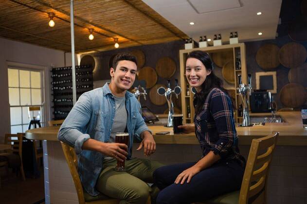 Portrait of smiling friends enjoying drinks at bar Portrait of smiling friends enjoying drinks while sitting on chairs at bar, model released, Cape Town, South Africa, 28.03.2017, 1024174.jpg, friendship, togetherness, bonding, holding, beer, drink, food and drink, refreshment, lifestyle, leisure, casual clothing, smiling, enjoying, alcohol, bar counter, bar, hotel, pretty, attractive, relaxing, handsome, beautiful, restaurant, sitting, food and drink establishment, counter, beer tap, drinking glass, beer glass, chair Indoors,Portrait,Looking at camera,Three Quarter Length