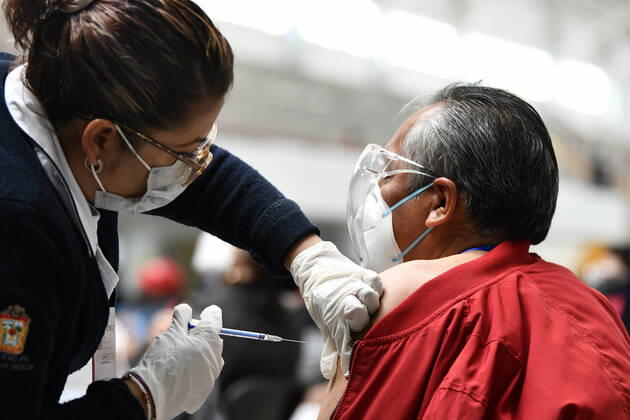 (210223) -- ECATEPEC, Feb. 23, 2021 -- A medical worker inoculates a citizen with a COVID-19 vaccine developed by Chinese pharmaceutical company Sinovac at a vaccination site in Ecatepec, Mexico, Feb. 22, 2021. Mexican health authorities on Monday began to vaccinate older adults with a COVID-19 vaccine developed by Chinese pharmaceutical company Sinovac, after a shipment of doses arrived on Saturday. Mexico s government designated the first shipment of the Sinovac vaccine to arrive in Ecatepec, a city in central State of Mexico that lies on the outskirts of the capital Mexico City. Early in the day, brigades of healthcare workers began to administer the vaccine to hundreds of residents aged 60 and over who went to the Las Americas 