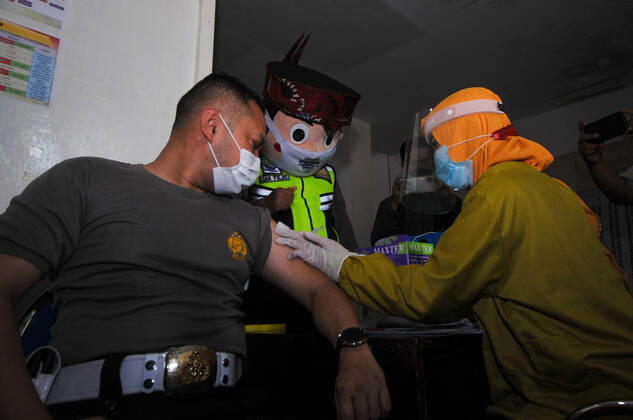 Mass vaccination for police personnel in Indonesia Police personnel get vaccinated for the COVID-19 coronavirus at the police headquarters in Surabaya, East Java, Indonesia on February 23, 2021. as part the country s efforts against the COVID-19 coronavirus pandemic. (Photo by Julian Romadhon INA Photo Agency)