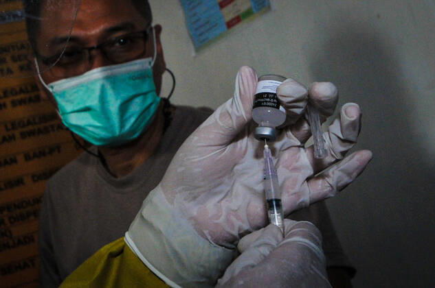 Mass vaccination for police personnel in Indonesia Police personnel get vaccinated for the COVID-19 coronavirus at the police headquarters in Surabaya, East Java, Indonesia on February 23, 2021. as part the country s efforts against the COVID-19 coronavirus pandemic. (Photo by Julian Romadhon INA Photo Agency)