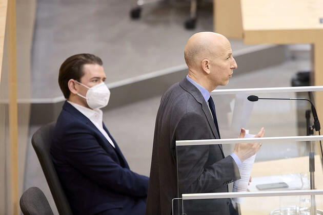 - Wien 24.02.2021 - Parlament Nationalrat - Heute fand im Nationalrat eine reguläre Sitzung statt mit den Themen, gesetzliche Regeln zum Homeoffice, Gratis-CoV-Tests in den Apotheken und Verlängerung zahlreicher CoV-Maßnahmen statt PHOTO: Arbeitsminister Martin Kocher (R ÖVP) bei seiner Rede und Bundeskanzler Sebastian Kurz (ÖVP) auf der Regierungsbank Vienna (AUSTRIA) - Today a regular meeting took place in the National Council with the topics, legal rules for home office, free CoV tests in pharmacies and the extension of numerous CoV measures. Nationalrat Sitzung
