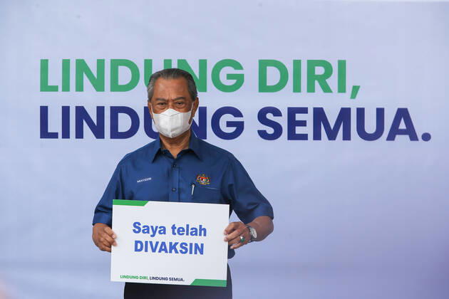 February 20, 2021, Putrajaya, Malaysia: Prime Minister, Muhyiddin Yassin displays a placard reading I have been vaccinated after receiving the first dose of Pfizer-BioNTech COVID-19 Vaccine in Putrajaya. .Malaysia will launch the largest immunization program ever to be carried out in the country. 532 Vaccination Centers nationwide are set to begin the National COVID-19 Immunization Program starting February 24, 2021. The first phase will involve 500,000 medical staff and non-medical staff. Putrajaya Malaysia - ZUMAs197 20210220_zaa_s197_456 Copyright: xCalvinxPanx